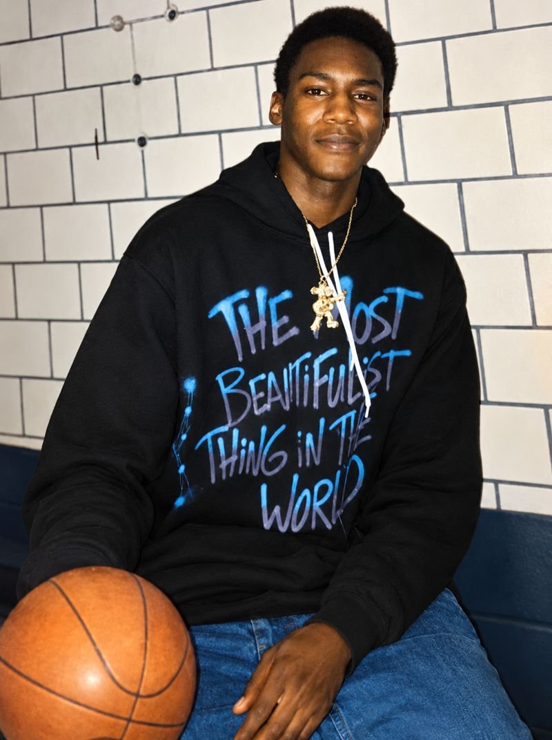 Dale smiling in a black hoodie, holding a basketball