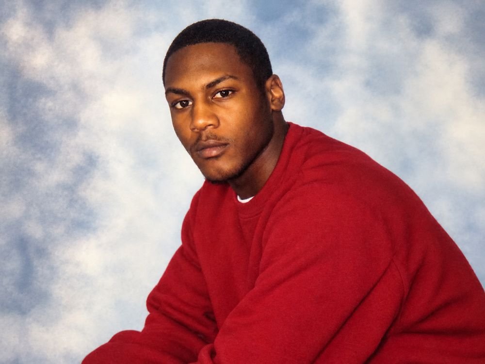 Dale in a red sweatshirt in front of a cloud backdrop