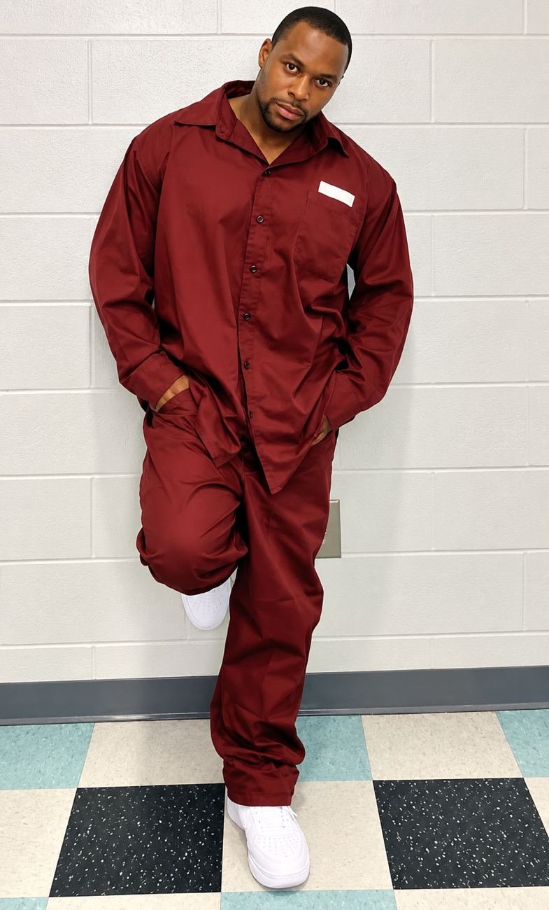 Randy D. Petty leaning against a wall in a burgundy uniform